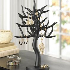 a black tree with earrings on it sitting on a table