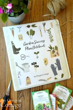 the garden success plan notebook surrounded by other gardening tools and supplies on a wooden table