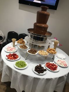 a table topped with lots of different types of desserts and pastries next to a flat screen tv