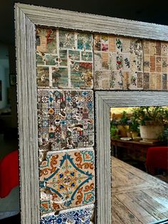 an old wooden frame with many different tiles on it and a mirror in the background