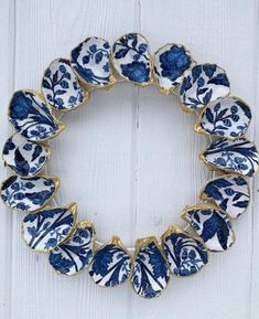 a close up of a wreath made out of blue and white plates on a wooden surface