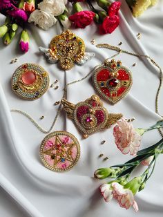 several necklaces and flowers on a white cloth