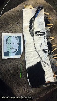 an image of a man's face on a piece of fabric next to knitting needles