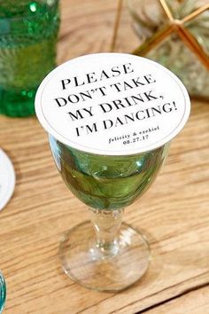 a wine glass with a sticker that says please don't take my drink i'm dancing