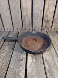 an old frying pan sitting on top of a wooden table