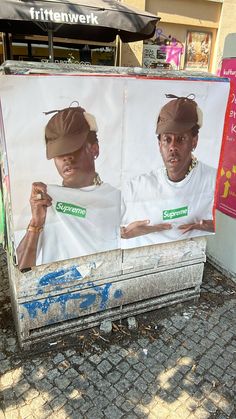 there is a billboard with two men in white shirts and brown hat on the street