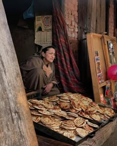 a woman sitting in front of a table filled with pancakes and other food on top of it