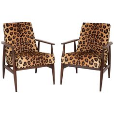 two chairs with leopard print upholstered on the back and arms, one in dark wood