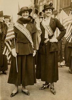 two women standing next to each other holding flags