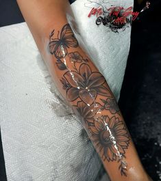 a woman's arm with flowers and butterflies on it