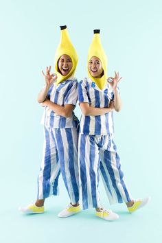 two people dressed in blue and white striped pajamas with bananas on their heads, posing for the camera