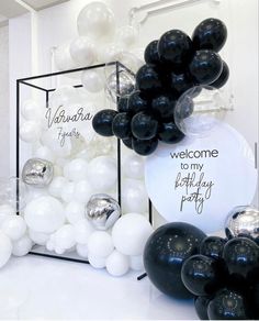 black and white balloons with welcome to my birthday party sign in the middle on display