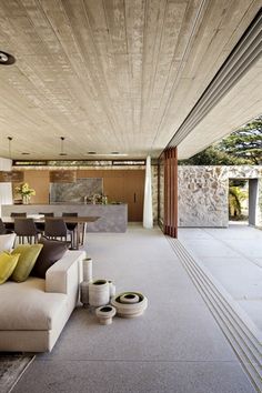 a living room filled with furniture next to a dining table and kitchen area in the background