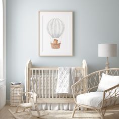 a baby's room with a rocking chair, crib and artwork on the wall