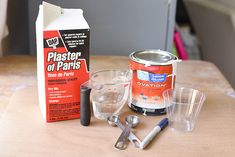 the contents of a paint can, measuring cup, and other items on a table