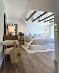 a bedroom with white walls and wooden floors