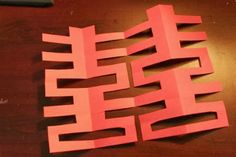 red paper cut out into squares on a table