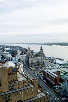 an aerial view of a city with tall buildings and water in the backround