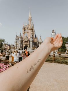 a person with a tattoo on their arm holding a small ball in front of a castle