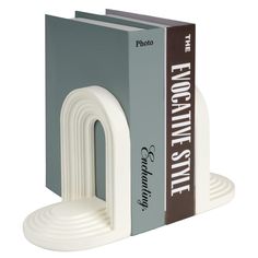 a white bookend with two books on it's sides and the front cover is open