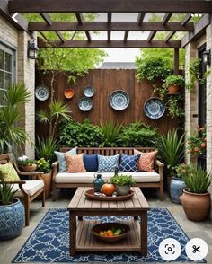 an outdoor living area with couches, tables and potted plants