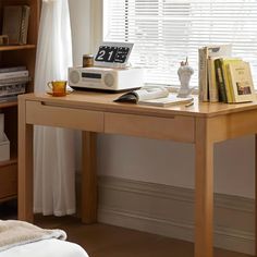 a wooden desk with a clock on top of it next to a bookshelf