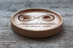 two wedding rings are placed on the back of a wooden button that says,'love is in the air '