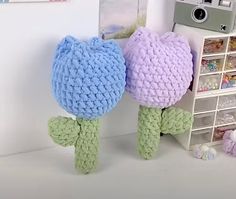 two crocheted stuffed animals sitting next to each other