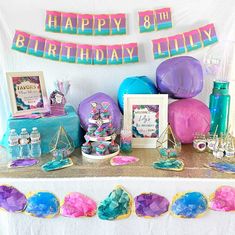 there is a birthday party table with balloons and decorations