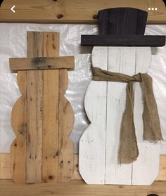 two snowmen made out of pallet boards and some burlocks on the wall