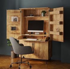 a desk with a computer on top of it and a chair in front of it