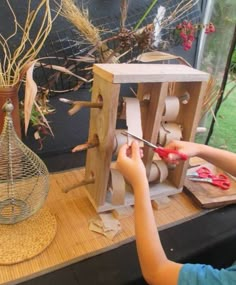 a young boy is working on an object in front of some plants and other things