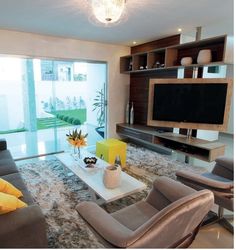 a living room with couches, chairs and a flat screen tv on the wall