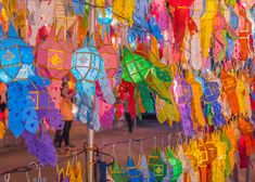 many colorful umbrellas are hanging from a pole