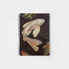 a spiral notebook with an image of a goldfish swimming in the water on a dark background