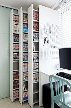 a computer desk sitting next to a book shelf