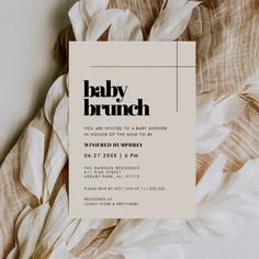 a baby brunch party is set up on a bed with white flowers and leaves