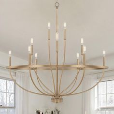 a large chandelier hanging from the ceiling in a living room with white walls