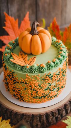 a cake decorated with leaves and a pumpkin on top