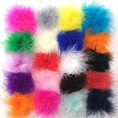 many colors of feathers are arranged in a square pattern on a white surface, with one color