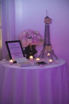 the eiffel tower is lit up with candles and flowers in front of it