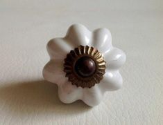 a white ceramic flower with a brown center