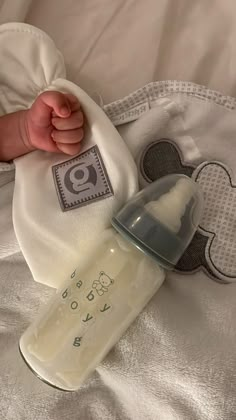 a baby's bottle and its cover on a bed