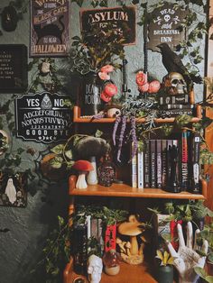 a shelf filled with lots of books next to a wall covered in plants and skulls