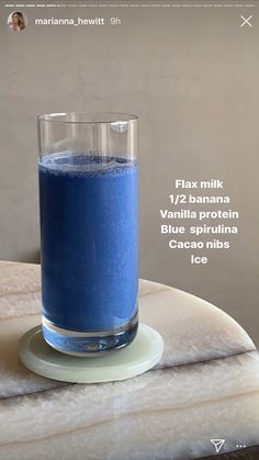 a glass filled with blue liquid sitting on top of a table