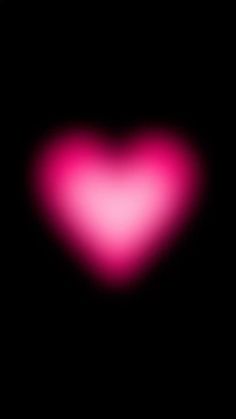 a heart shaped object in the dark with pink light coming from it's center