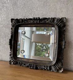 a mirror sitting on top of a wooden table