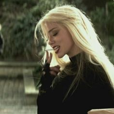 a woman with long blonde hair talking on a cell phone