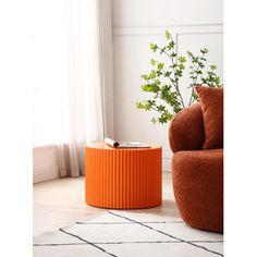 an orange table sitting in the middle of a living room next to a chair and potted plant