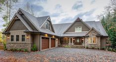 a large house in the woods with lots of leaves on the ground